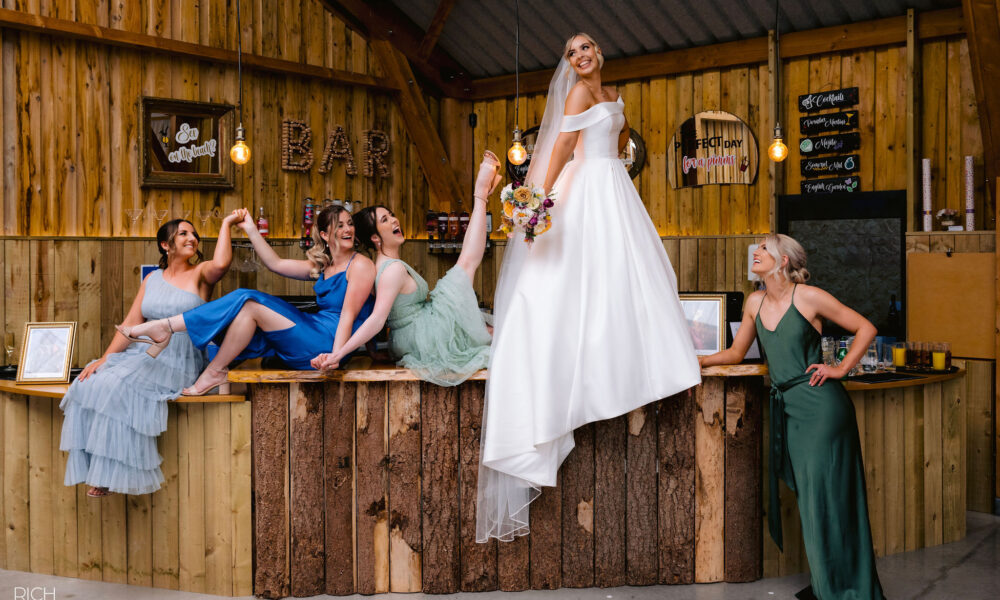 Bride on the bar inside wedding barn